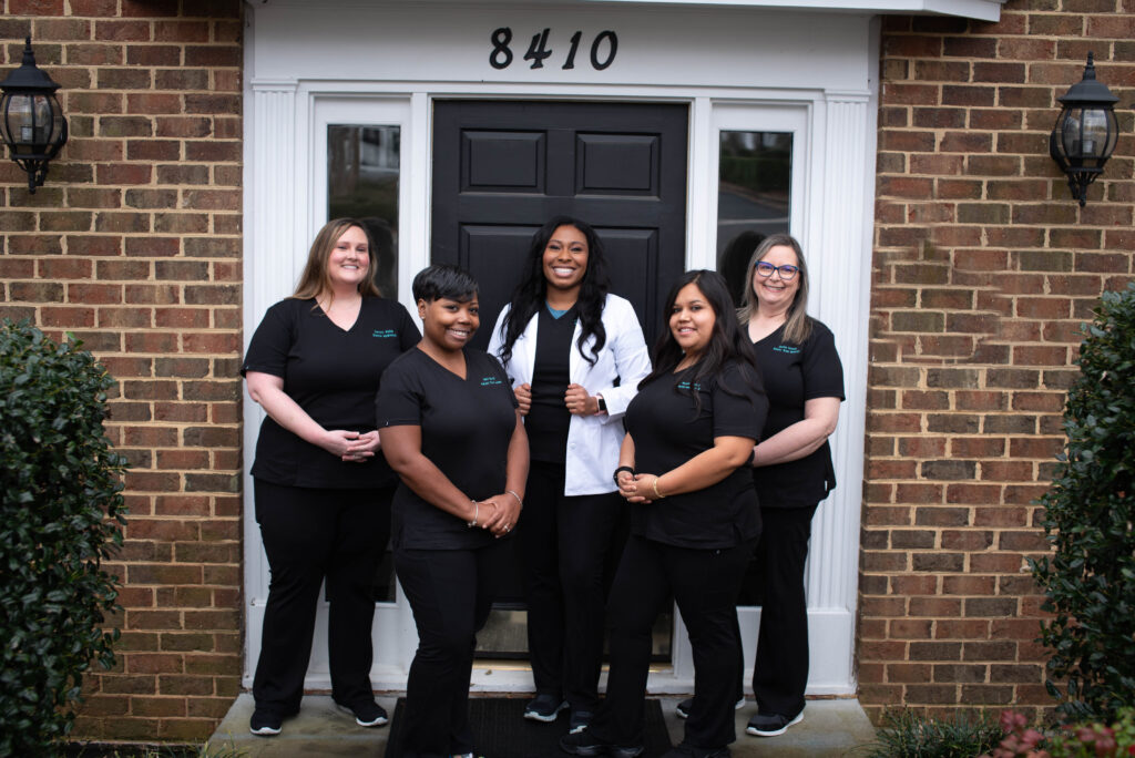 Dental office staff members posing outside their studio office